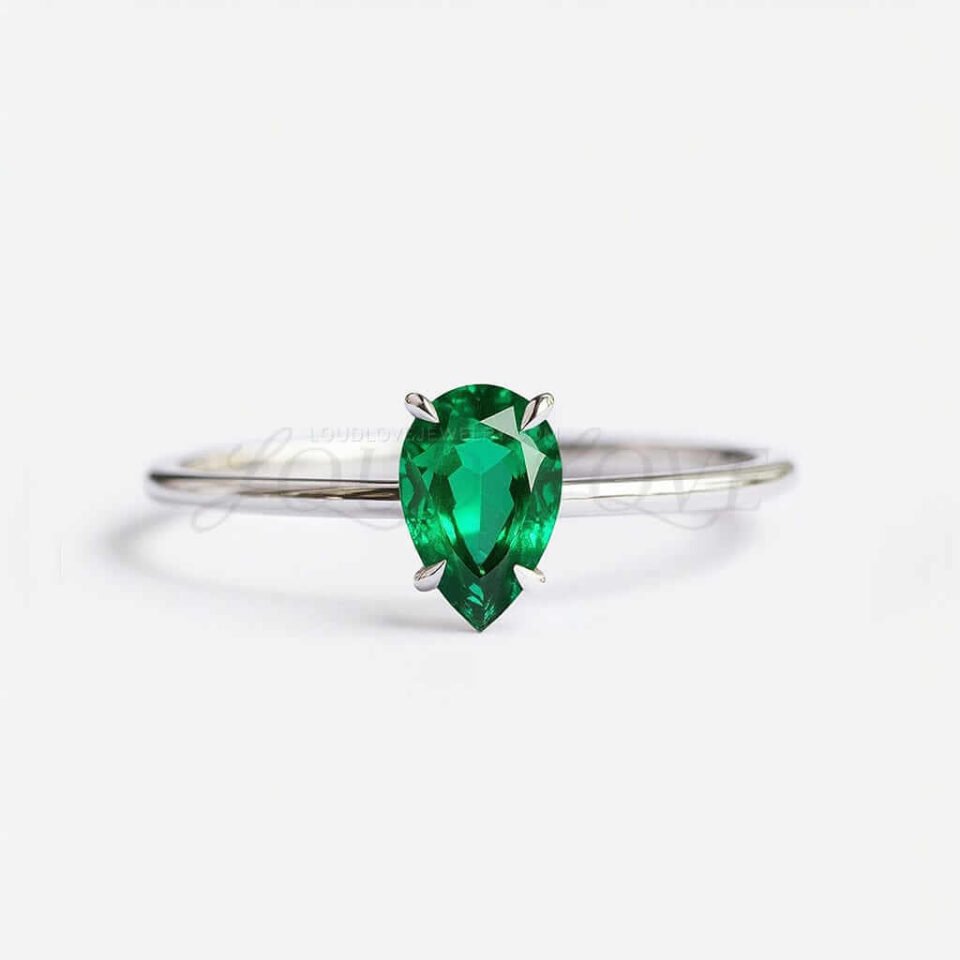Pear cut lab-grown emerald solitaire in a 4-prong white gold setting.