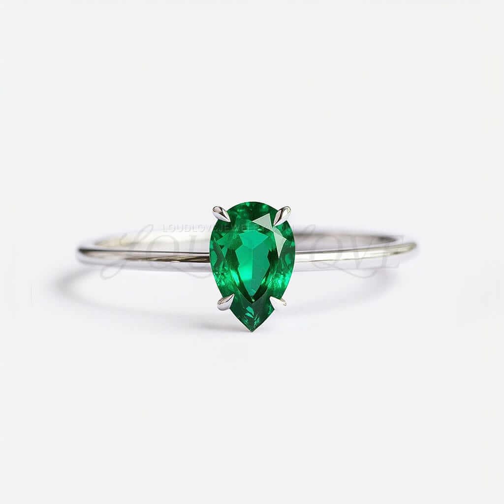 Pear cut lab-grown emerald solitaire in a 4-prong white gold setting.
