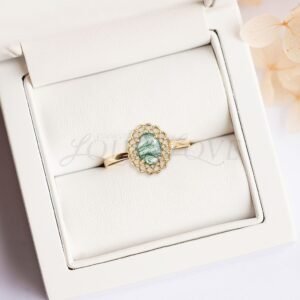 Moss agate ring with lace halo resting in stylish display case.