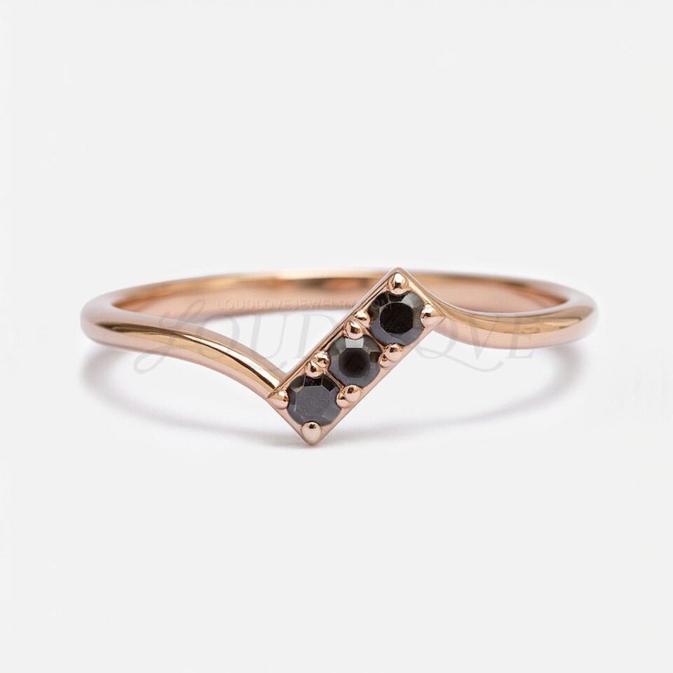 Promise ring in 14k rose gold with 3 black stones.