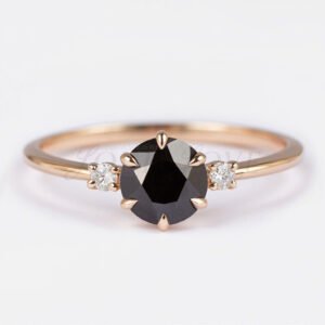 Round black diamond ring with two side stones in a 6-prong gold three-stone setting.