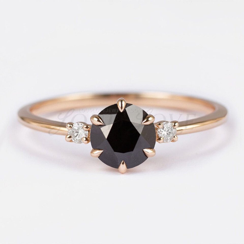 Round black diamond ring with two side stones in a 6-prong gold three-stone setting.