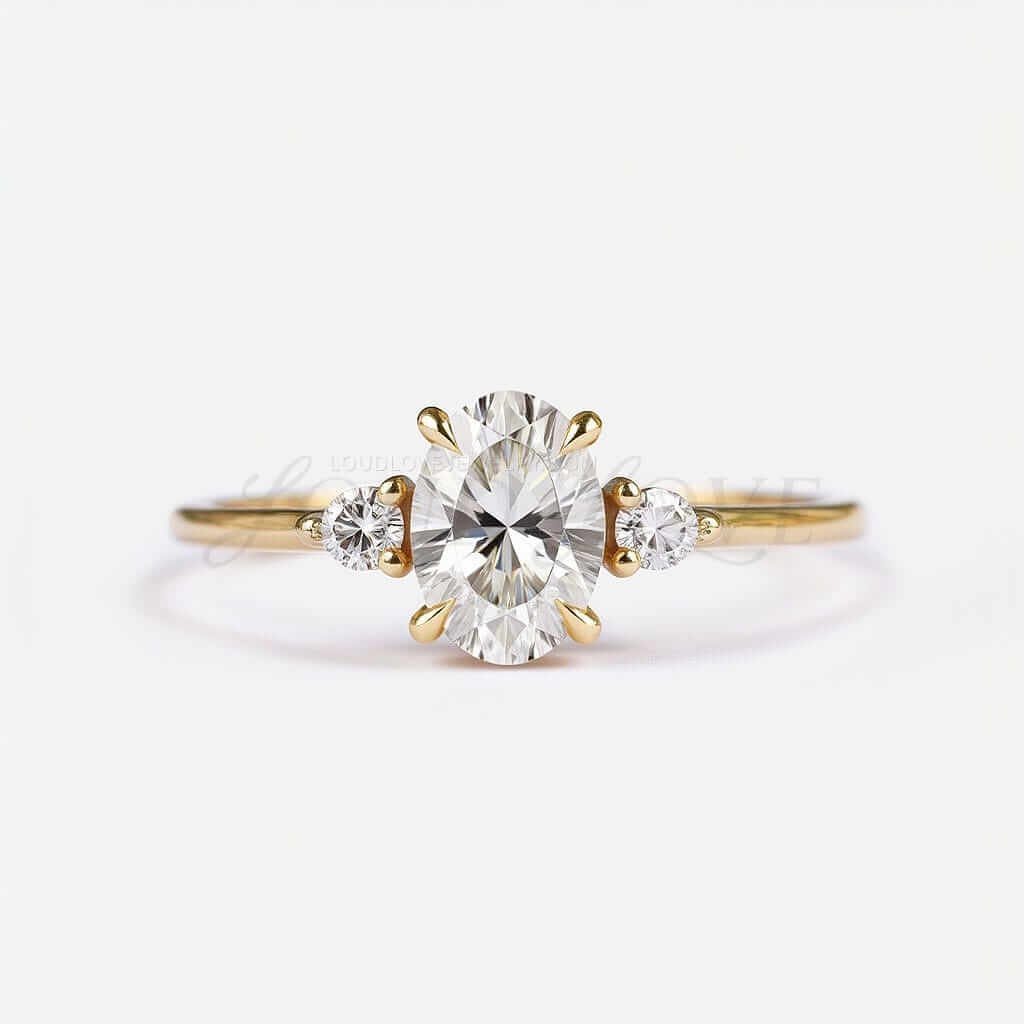 Three-stone oval engagement ring with round-cut side stones and 4 prongs.