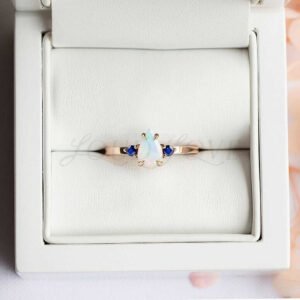 Opal and lab sapphires, nestled in a refined three-stone ring display.
