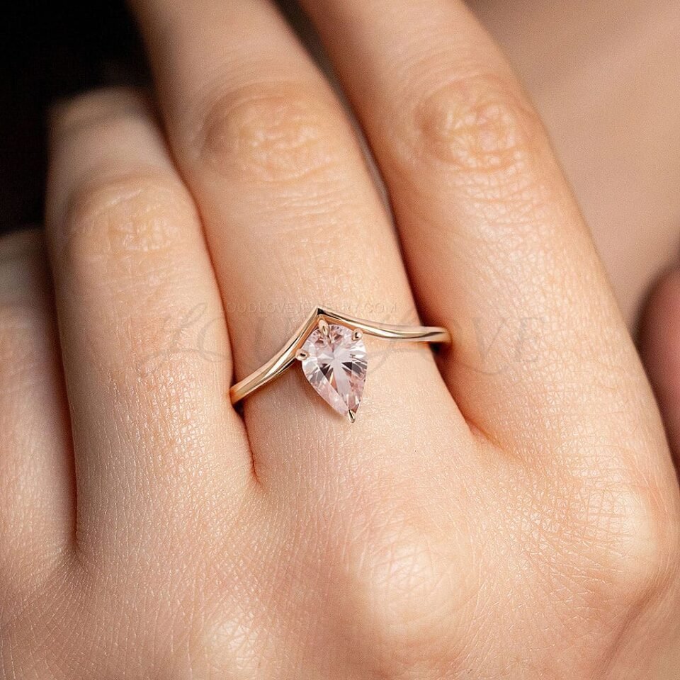 Elegant pink morganite in a pear shape, styled with a sculpted rose gold V-shaped band.