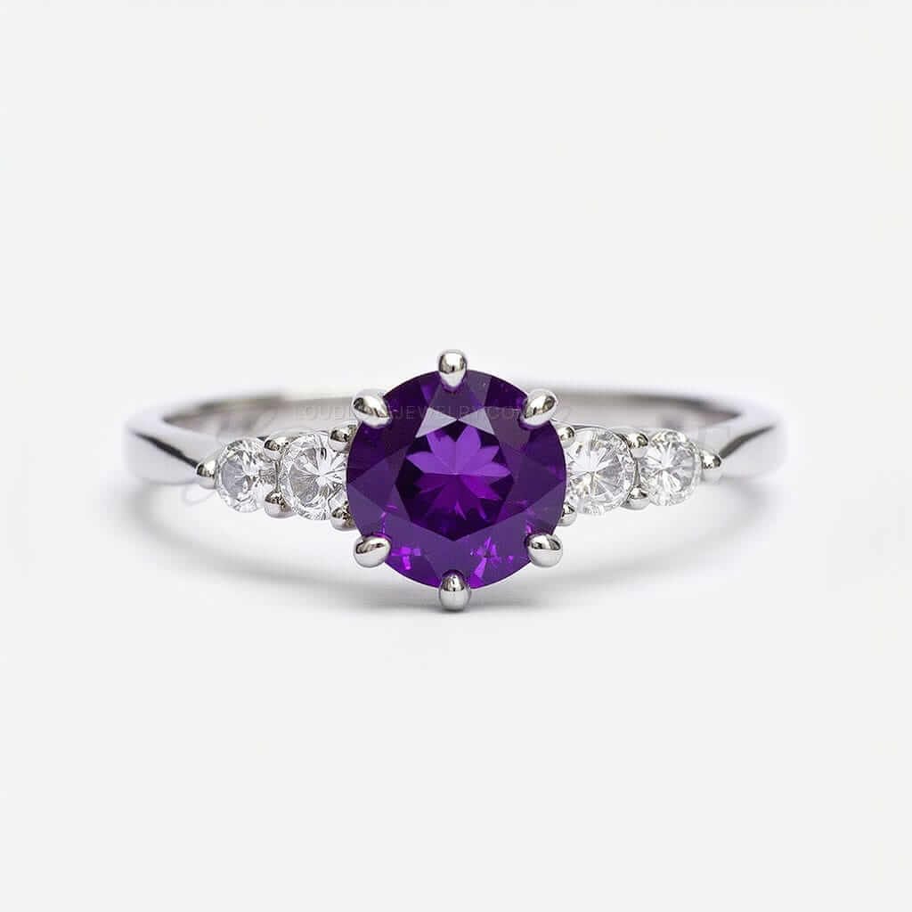 Large round amethyst flanked by four moissanite stones in a white gold five-stone engagement ring.