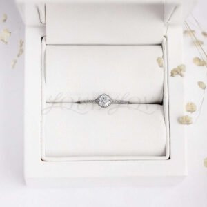 Milgrain engagement ring with round moissanite and scale-like band, solitaire style.