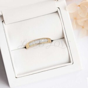 Gold men's ring with channel-set baguette diamonds displayed in a padded case.